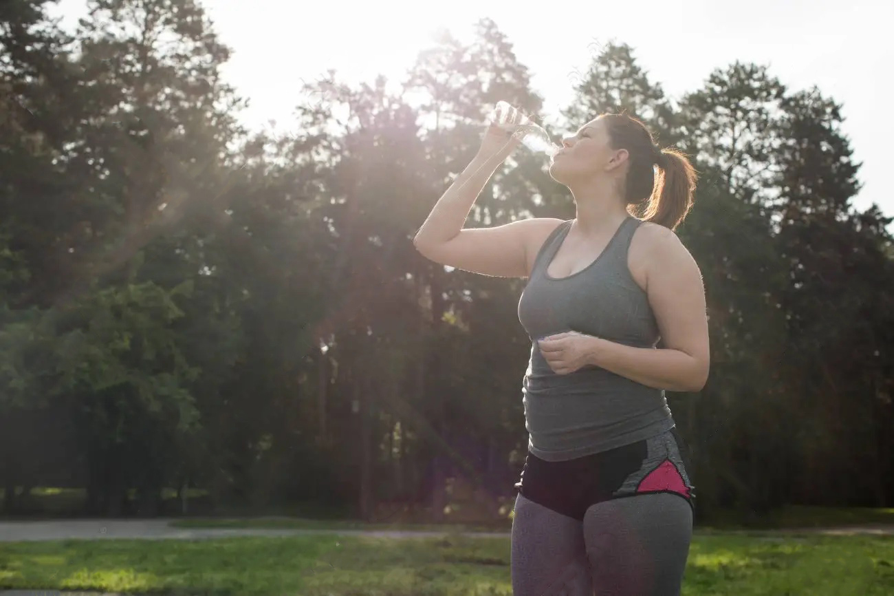 overweight-woman-drinking-water-after-workout