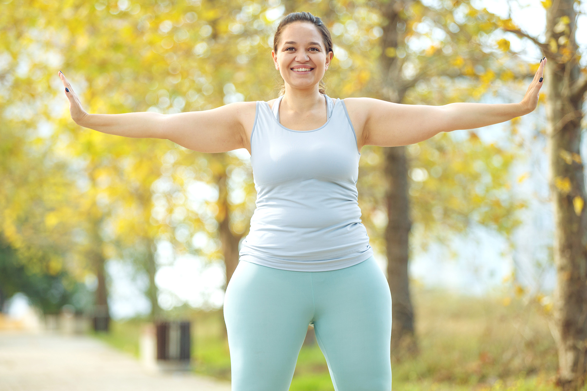 an-attractive-plus-size-woman-in-a-sports-top-and-leggings-goes-in-for-sports-works-out-in-a-cozy-ci